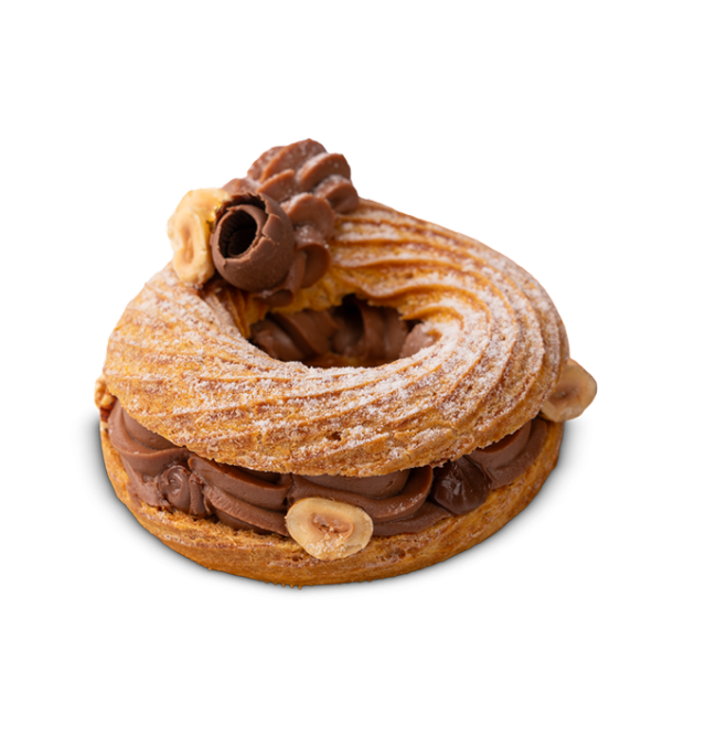 Ring-shaped Paris-Brest pastry filled with chocolate hazelnut cream, topped with a chocolate curl and whole hazelnuts.