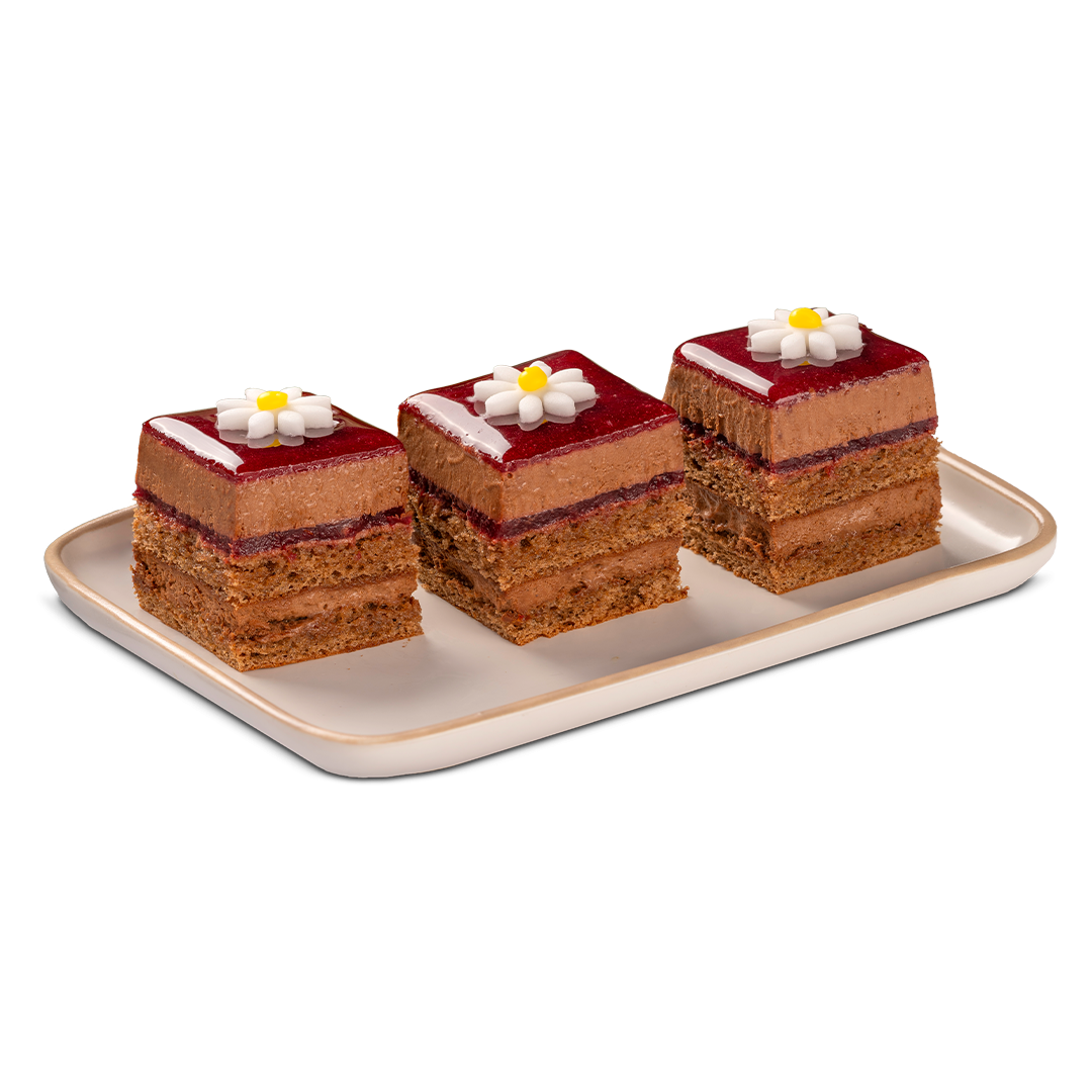 Three square layered chocolate cakes topped with red glaze and white sugar flowers, arranged on a rectangular tray.